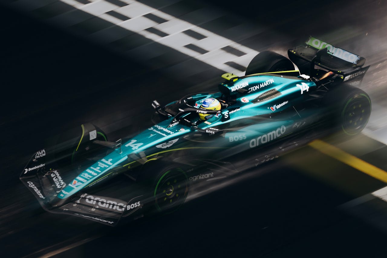 High-speed Formula 1 car racing past the finish line, showcasing sleek design and motion blur.